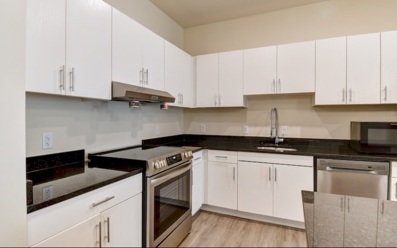 White apartment kitchen with stainless steel appliances